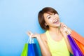 Happy woman holding shopping bags before blue background Royalty Free Stock Photo