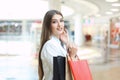 Happy woman holding shopping bags and smiling at the mall. Royalty Free Stock Photo