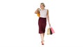 Happy woman holding shopping bags, smiling and walking on white Royalty Free Stock Photo