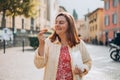 Happy woman holding Sicilian cannolo tube pastry filled with cream. Travel, Italy and holidays concept. Young women