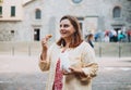 Happy woman holding Sicilian cannolo tube pastry filled with cream. Travel, Italy and holidays concept. Young women