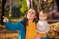 Happy woman holding small kid pointing with finger Royalty Free Stock Photo