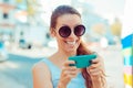 Happy woman holding smartphone smiling celebrating his success over city scape background Royalty Free Stock Photo