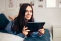 Happy Woman Holding Tablet Relaxing at Home