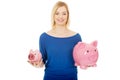 Happy woman holding two piggybanks.