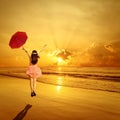 Happy Woman holding umbrella and Jumping in Sea Sunset Royalty Free Stock Photo