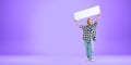 Happy woman holding up blank mock up banner, empty purple background