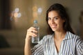 Happy woman holding water bottle at home in the night Royalty Free Stock Photo