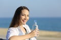 Happy woman holding a water bottle and looking at you outdoors Royalty Free Stock Photo