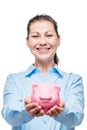 Happy woman holds a piggy bank full of money, photo