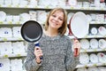 Happy woman housewife chooses frying pan Royalty Free Stock Photo