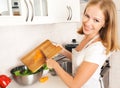 Happy woman housewife preparing salad in the kitchen