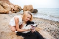 Happy woman hugging her dog and smiling on the beach Royalty Free Stock Photo