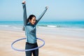 Happy woman with hula hoop on the beach