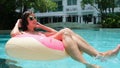 Happy woman and inflatable swim ring in the shape of a donut in the pool and listens to music at the store. Royalty Free Stock Photo