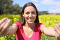 Happy woman inviting you to follow her in a field