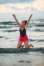 Happy woman jump in the air on the beach at sea Royalty Free Stock Photo