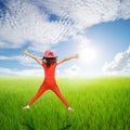 Happy woman jump in green rice fields and clouds sky Royalty Free Stock Photo