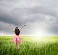 Happy woman jump and raincloud in green field