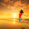 Happy Woman Jumping on Beach Sunset on red T-shirt Royalty Free Stock Photo