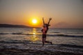 Happy woman jumping and enjoy life on the beach vacation at the sunrise. Early morning, the sun rises and shines in sea Royalty Free Stock Photo