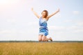 Happy woman jumping and enjoying life in field at daylight Royalty Free Stock Photo