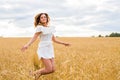 Happy woman jumping in golden wheat Royalty Free Stock Photo