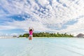 Happy woman jumping for joy in ocean on tropical island in Maldives Royalty Free Stock Photo