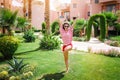 Happy woman jumping over the grass on the hotel Royalty Free Stock Photo