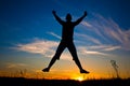 Happy woman jumping over the sunset blue sky Royalty Free Stock Photo