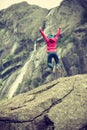 Happy woman jumping on rock in mountains Royalty Free Stock Photo