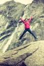 Happy woman jumping on rock in mountains Royalty Free Stock Photo