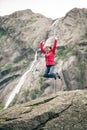 Happy woman jumping on rock in mountains Royalty Free Stock Photo