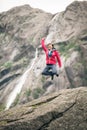 Happy woman jumping on rock in mountains Royalty Free Stock Photo