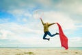 Happy woman jumping with scarf on beach Royalty Free Stock Photo