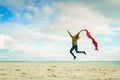 Happy woman jumping with scarf on beach Royalty Free Stock Photo