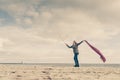 Happy woman jumping with scarf on beach Royalty Free Stock Photo