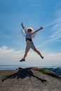 Happy woman is jumping on the top of the mountain. He rejoices at the success of victory over himself, overcoming Royalty Free Stock Photo