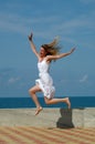 Happy woman jumps in blue sky