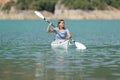 Happy woman in a kayak rowing in a lake