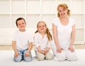 Happy woman and kids indoors sitting on the floor Royalty Free Stock Photo