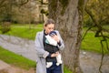 Happy woman kissing her baby that she is holding and carrying in a baby carrier Royalty Free Stock Photo