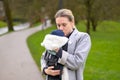 Happy woman kissing her baby that she is holding and carrying in a baby carrier Royalty Free Stock Photo