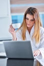 Happy woman in the kitchen reading he news on her laptop Royalty Free Stock Photo