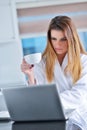 Happy woman in the kitchen reading he news on her laptop Royalty Free Stock Photo