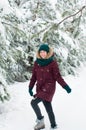 Happy woman walking through a snowy forest