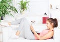 Happy woman with laptop lying on the sofa Royalty Free Stock Photo