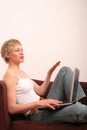 Happy woman with laptop is talking to somebody Royalty Free Stock Photo