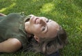 Happy woman laying on grass smiling