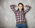 Happy woman leaning against a gray wall looking at camera Royalty Free Stock Photo
